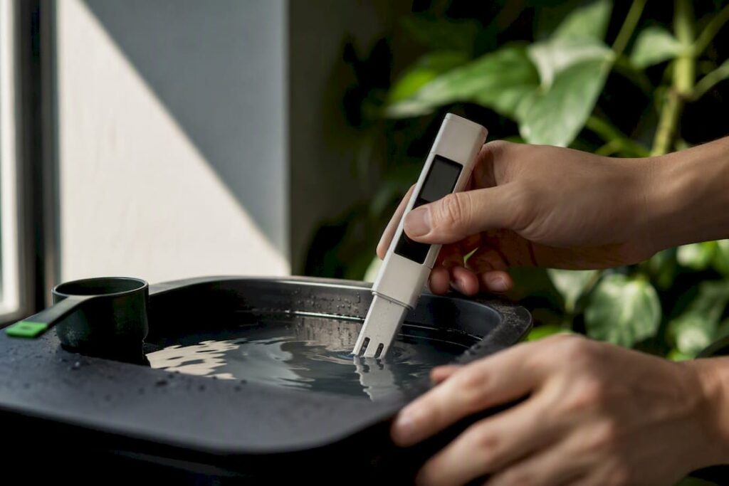 Grower checking EC in a hydroponic reservoir with a digital meter, following a hydroponic nutrient schedule.